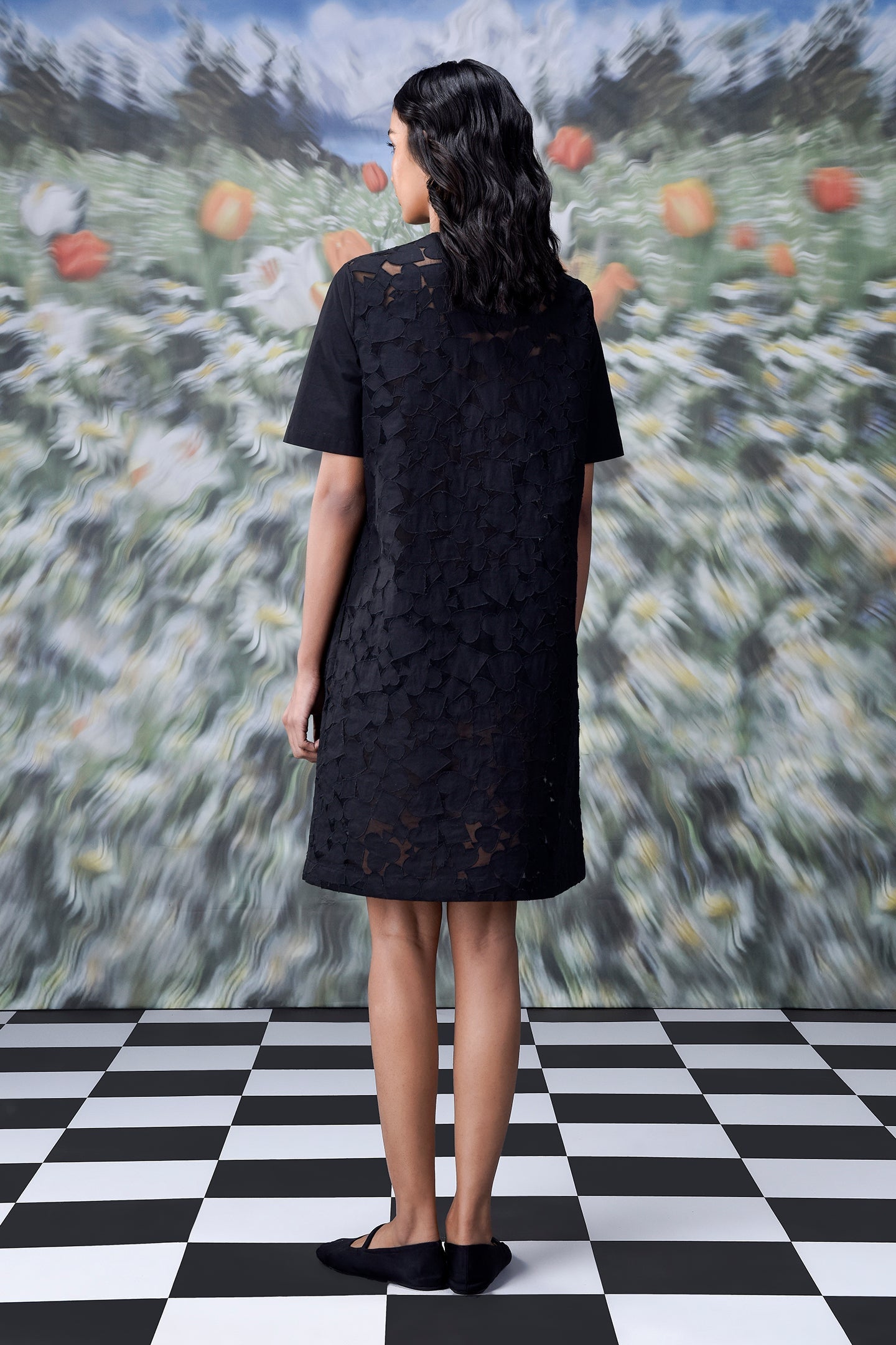 Back view of model wearing Stylera relaxed fit black dress for women in lace shift style