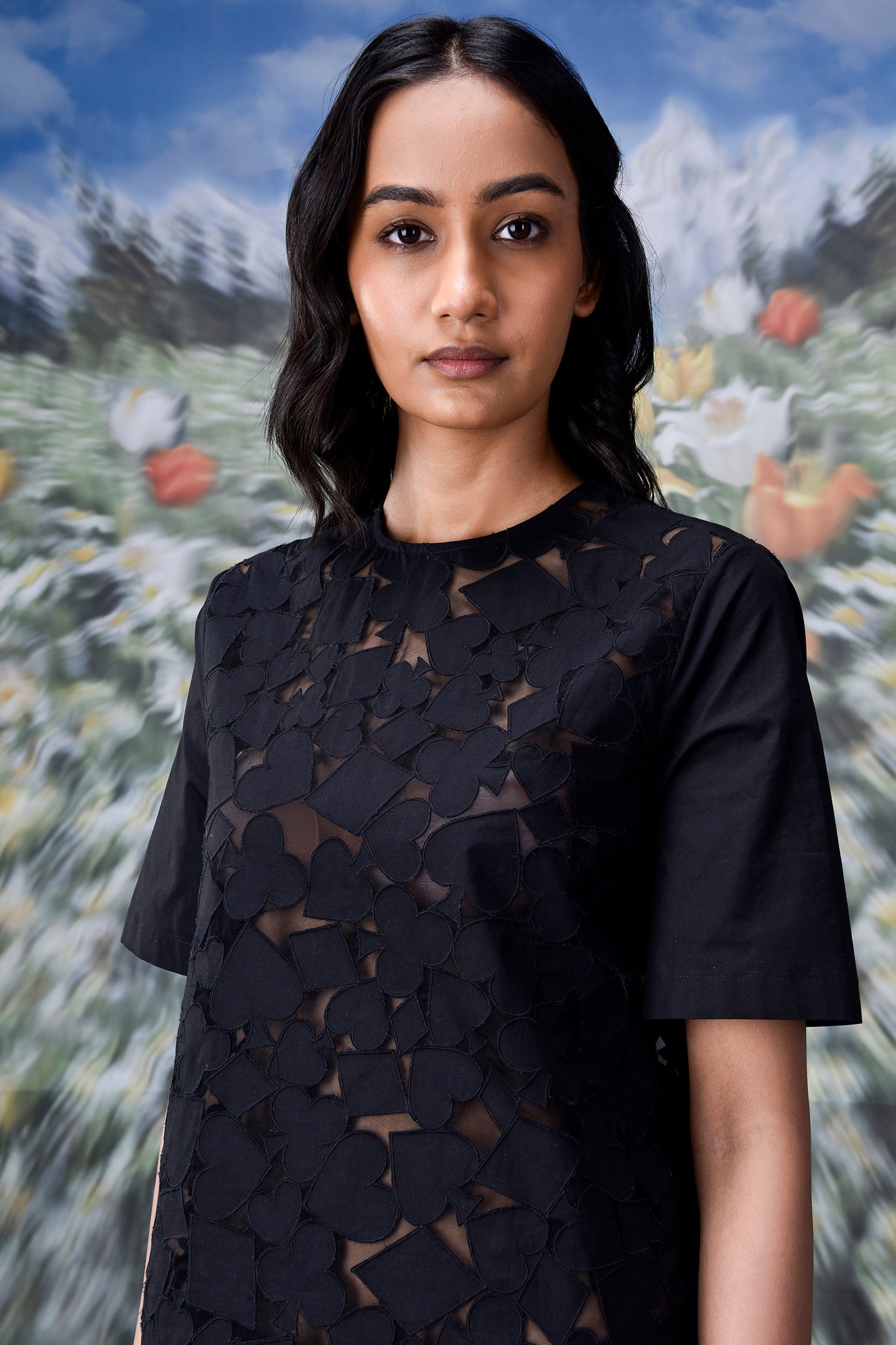 Model wearing Stylera relaxed fit black dress for women with short sleeves and floral cutout overlay