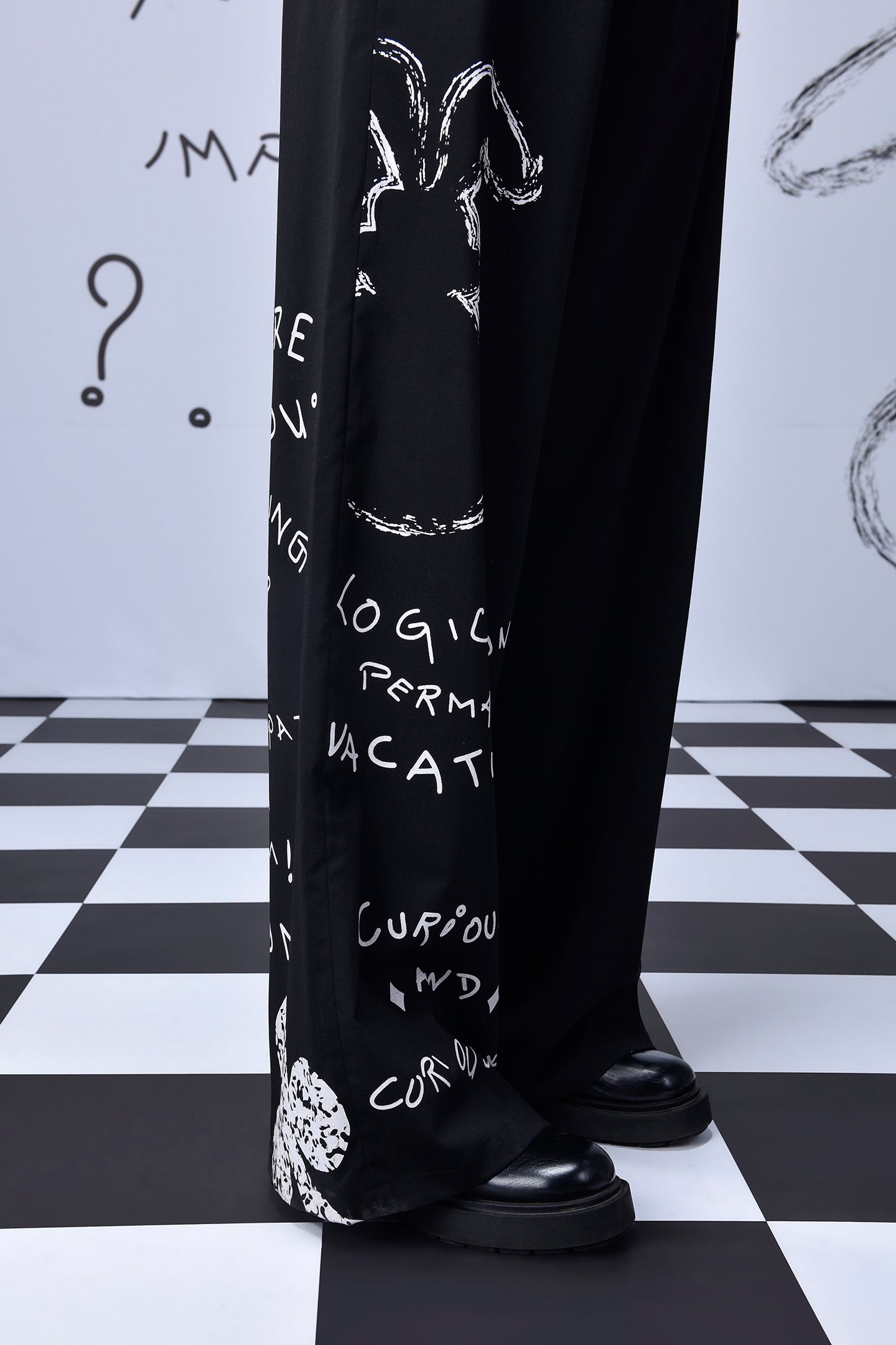 Stylera black graffiti wide leg relaxed fit dungaree for women shown over platform shoes on checkered floor