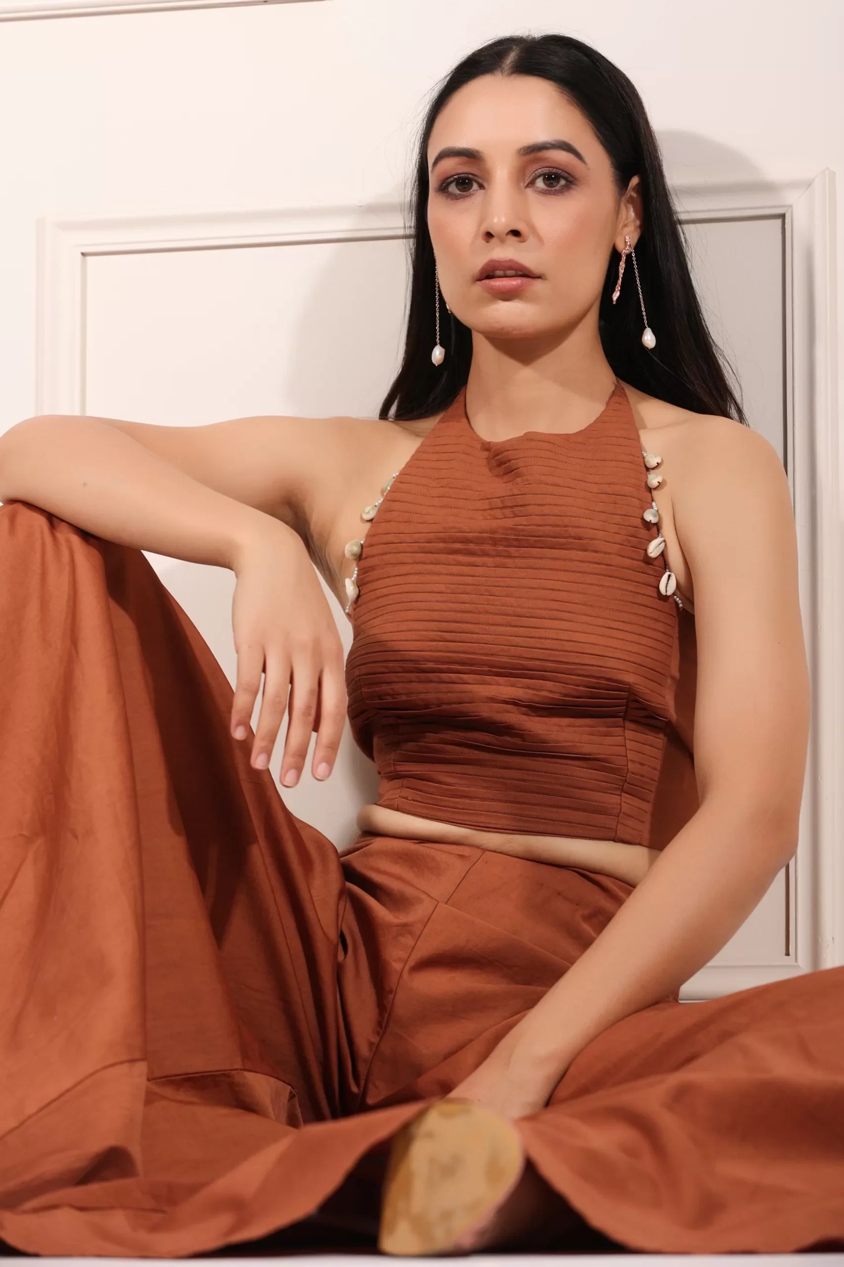 Model wearing a rust brown crop top and palazzo set with unique detailing for a stylish look