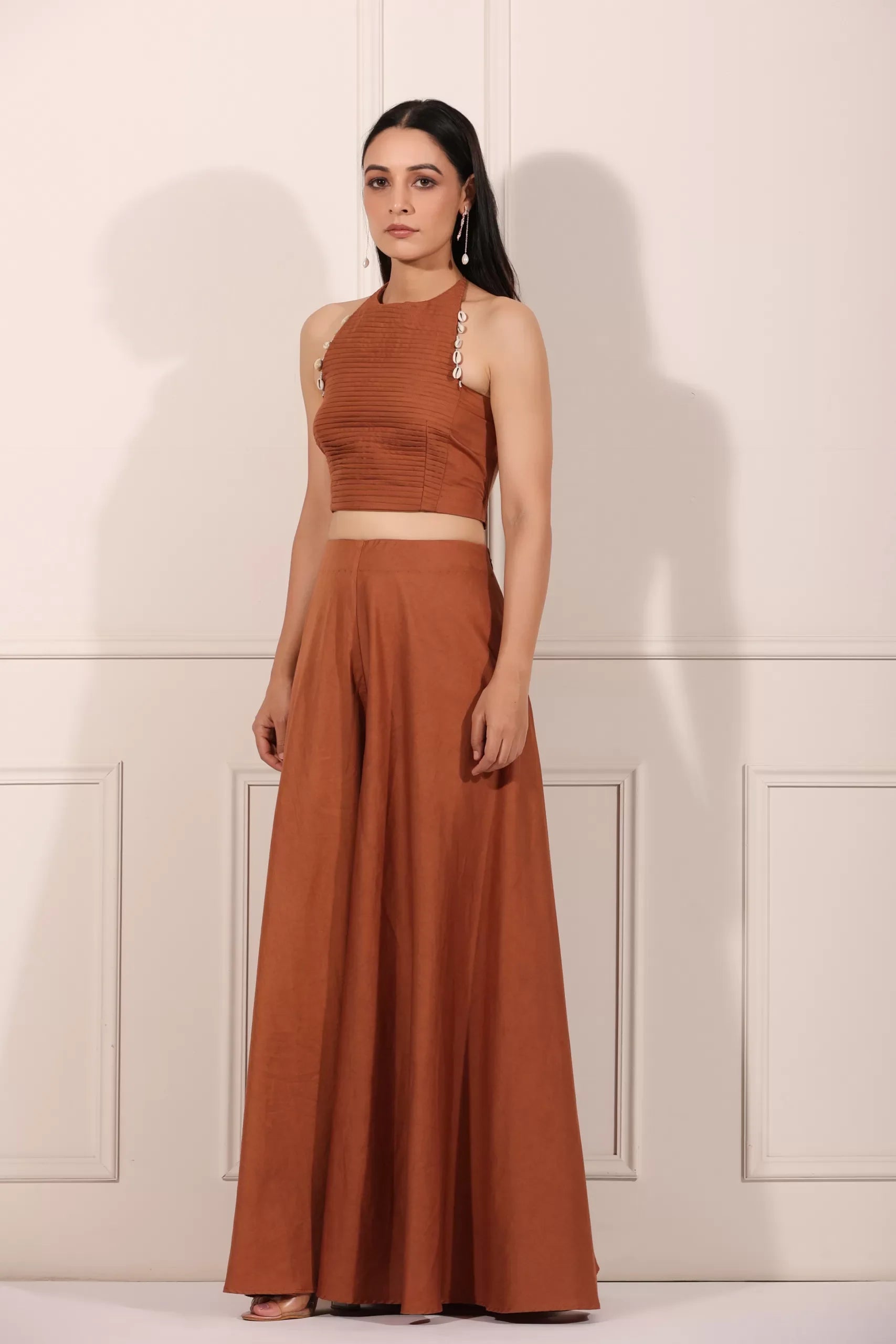Model wearing a rust brown crop top and palazzo set, showcasing a stylish and elegant look