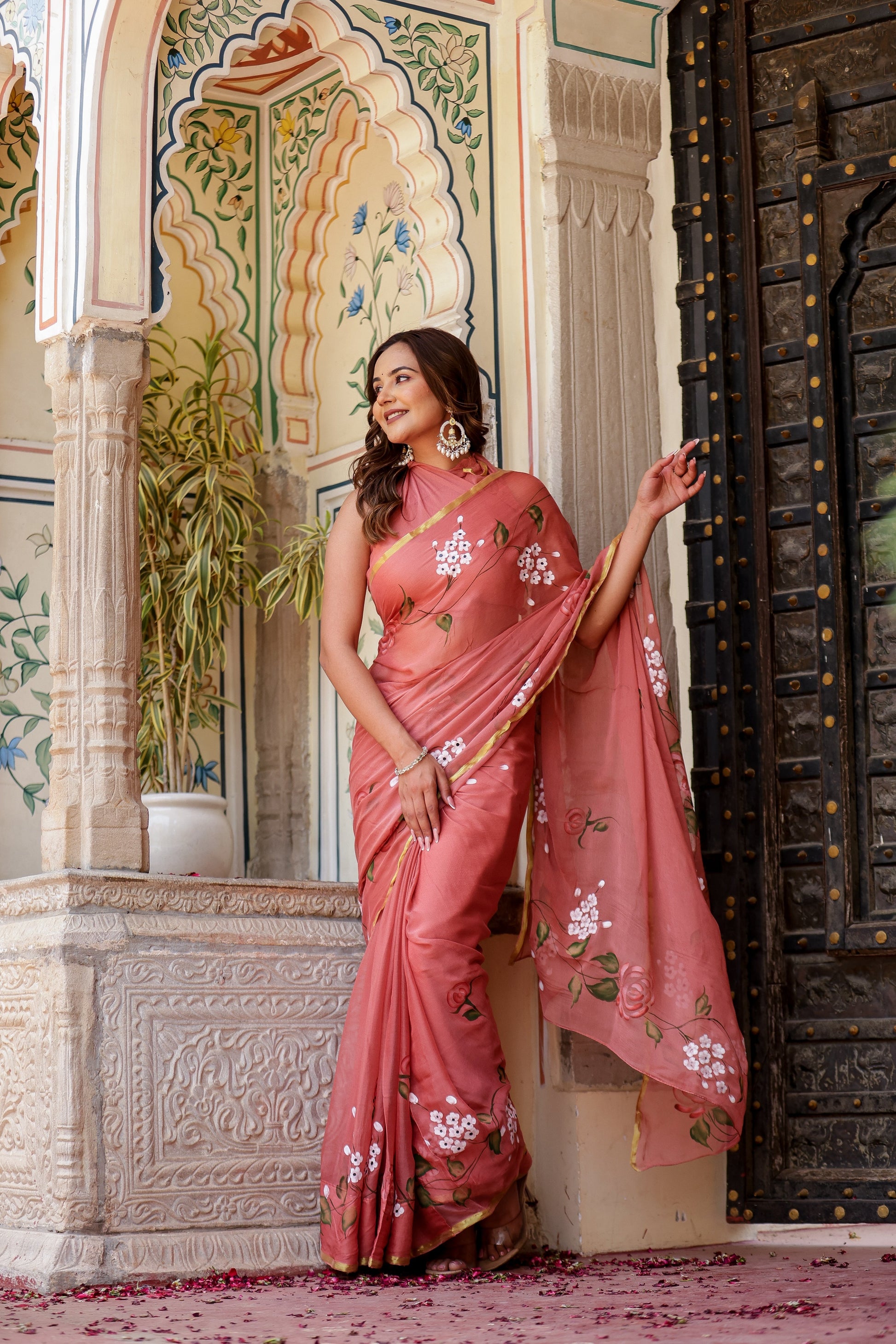 Elegant rust saree with floral hand painting, perfect for festive occasions and celebrations