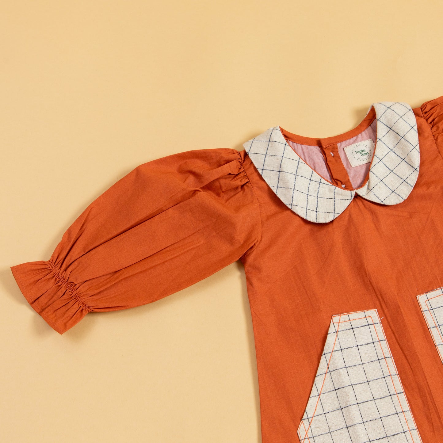 Stylera rustic dress for fall outings in rust color with a checkered pocket and puff sleeves