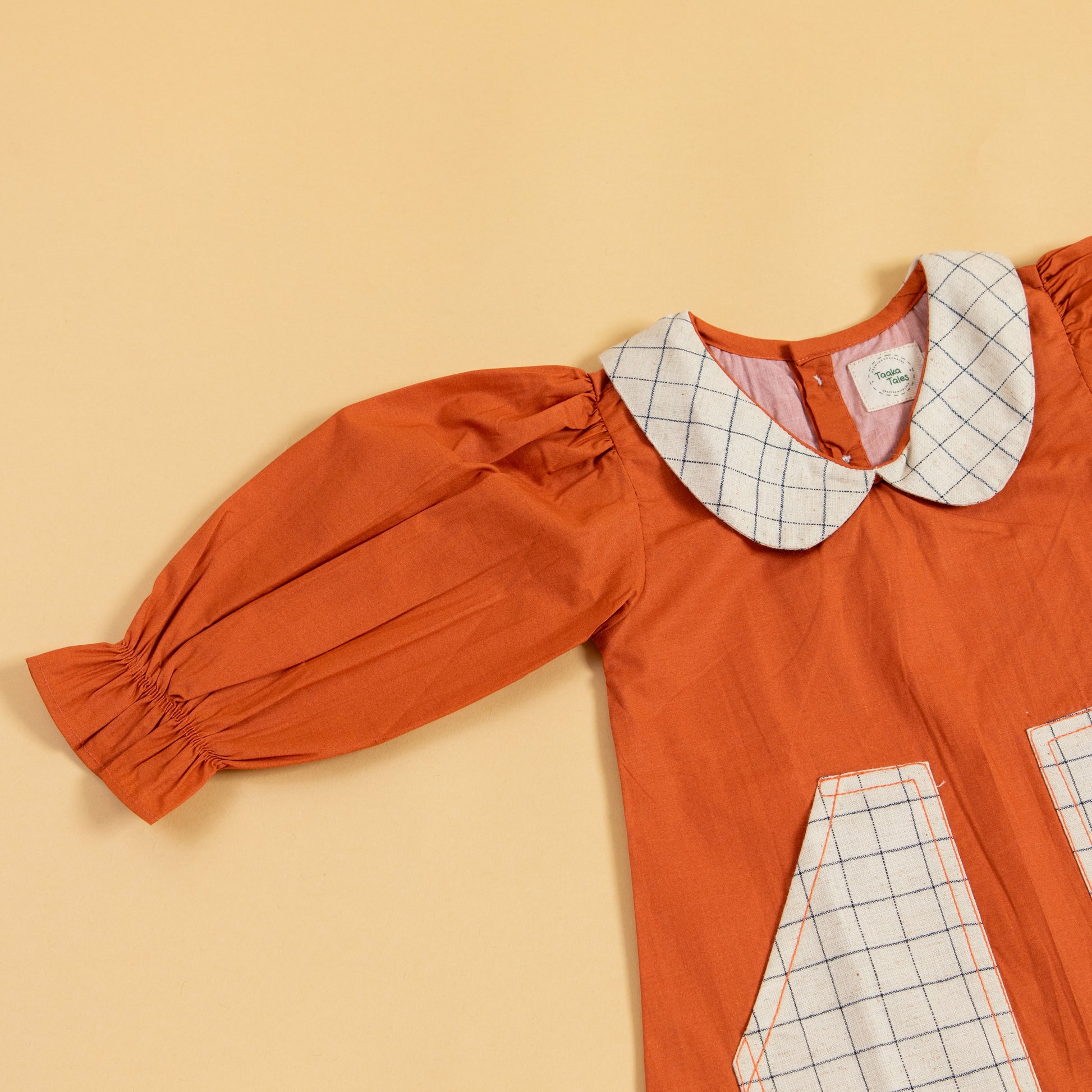 Stylera rustic dress for fall outings in rust color with a checkered pocket and puff sleeves