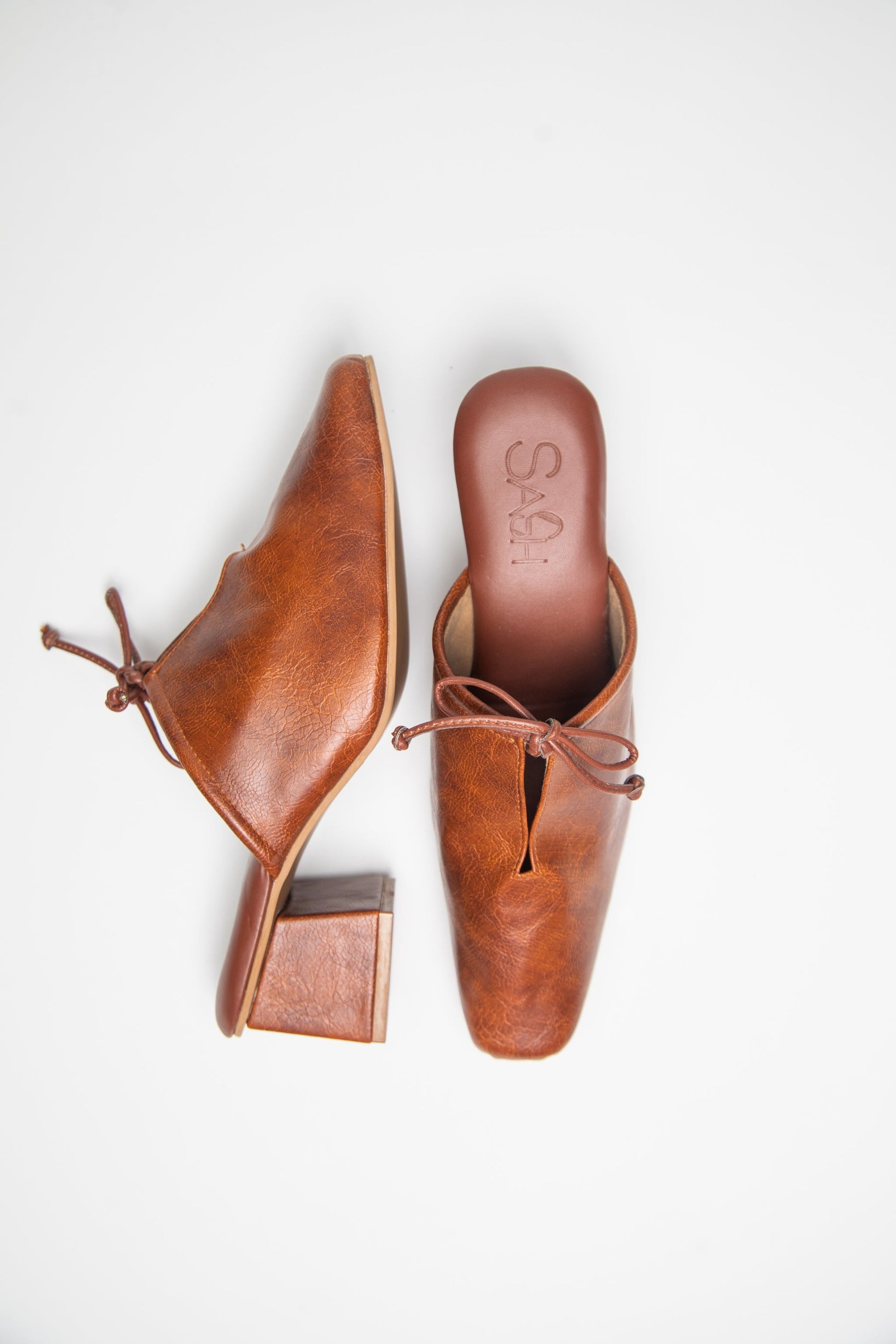 Brown slip-on block heel shoes by stylera with a low stacked heel and bow detail