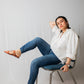 Woman wearing trendy tan flats for women by Stylera paired with casual white shirt and blue jeans
