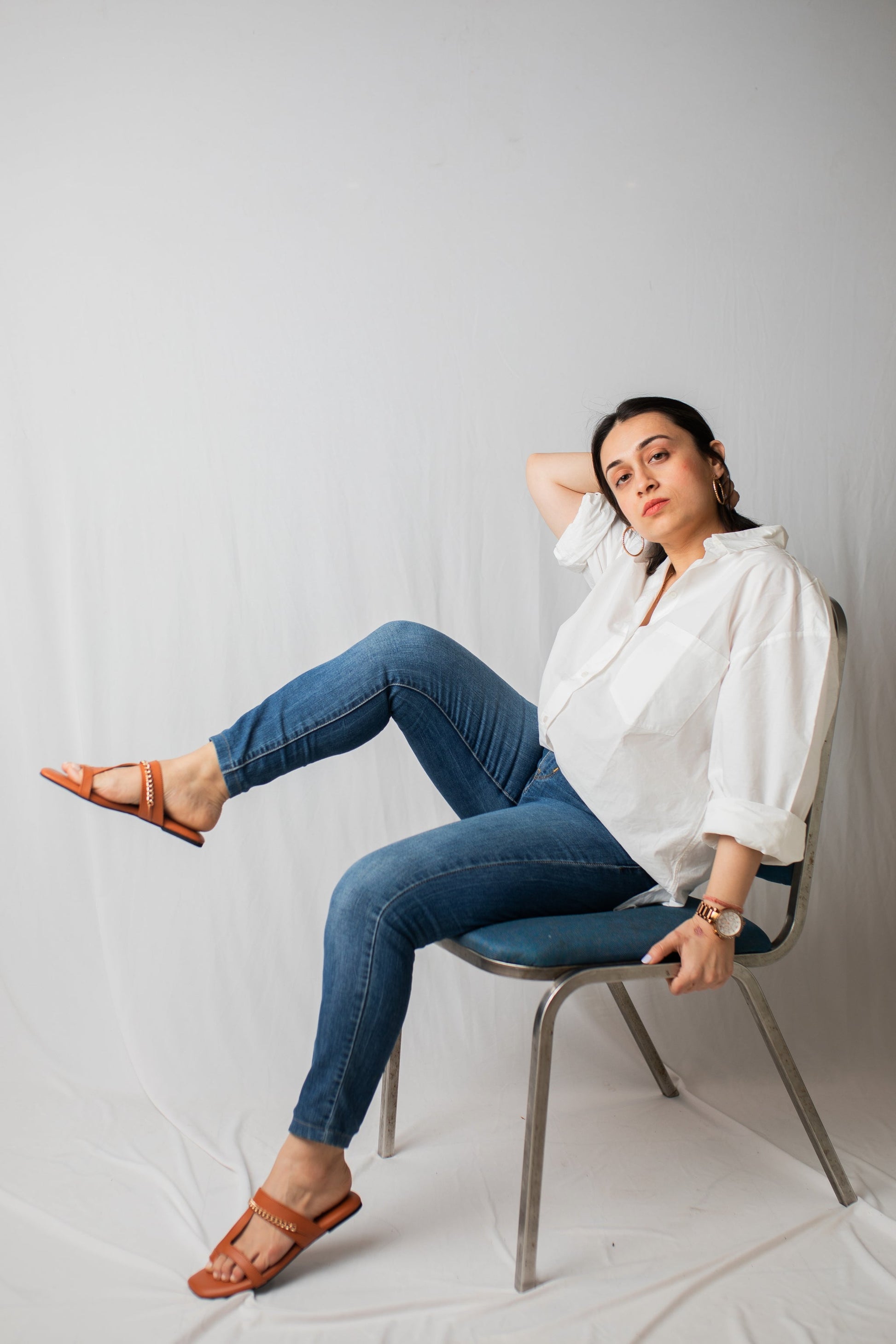 Woman wearing trendy tan flats for women by Stylera paired with casual white shirt and blue jeans
