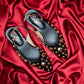 stylera black heels with gold studs on red satin background trendy gold accent footwear