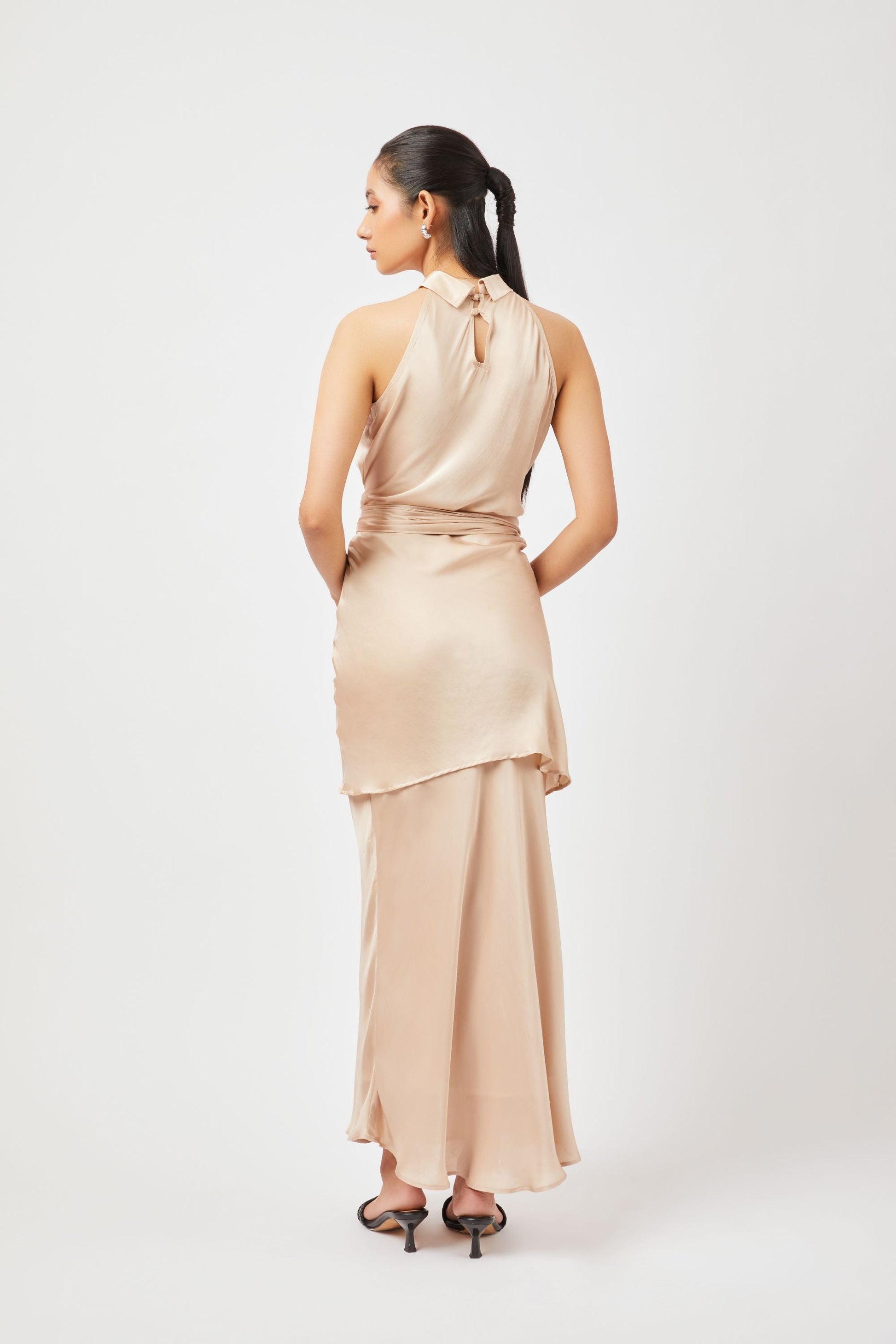 Stylera satin halter mini dress in champagne color shown from the back with long flowing skirt and tie neck detail