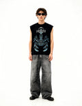 Person wearing a black sleeveless shirt with a graphic design and gray pants on a white background