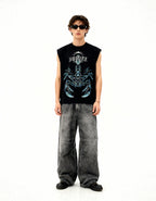 Person wearing a black sleeveless shirt with a graphic design and gray pants on a white background