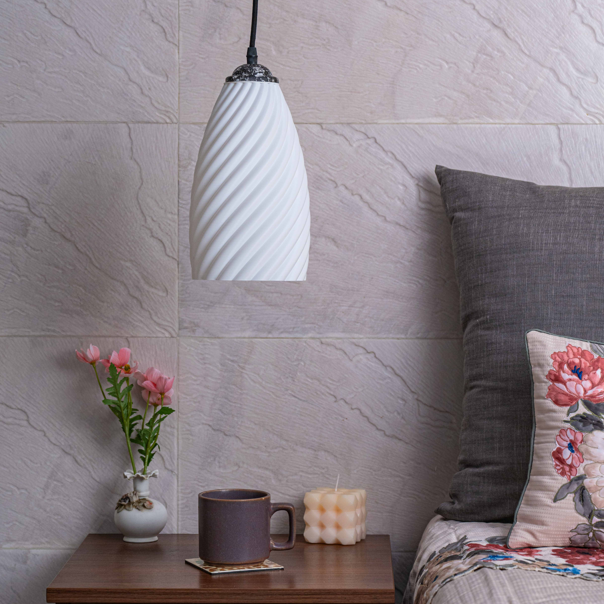 Sculpted white hanging lamp from Sozori illuminating a cozy living space with decor elements