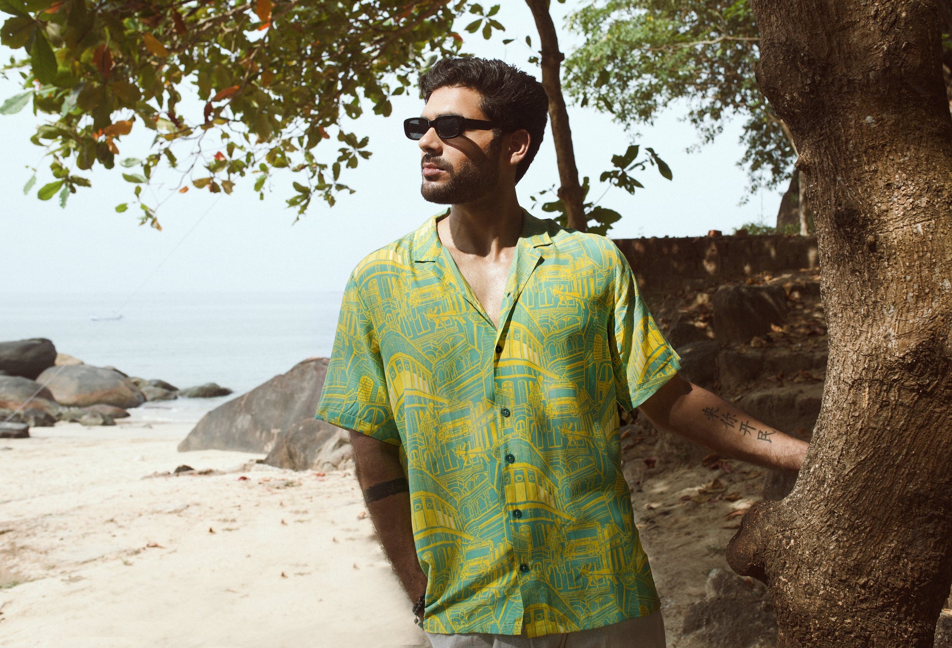 Men's seagreen oversize shirt for men featuring a colorful tropical print in a beach setting