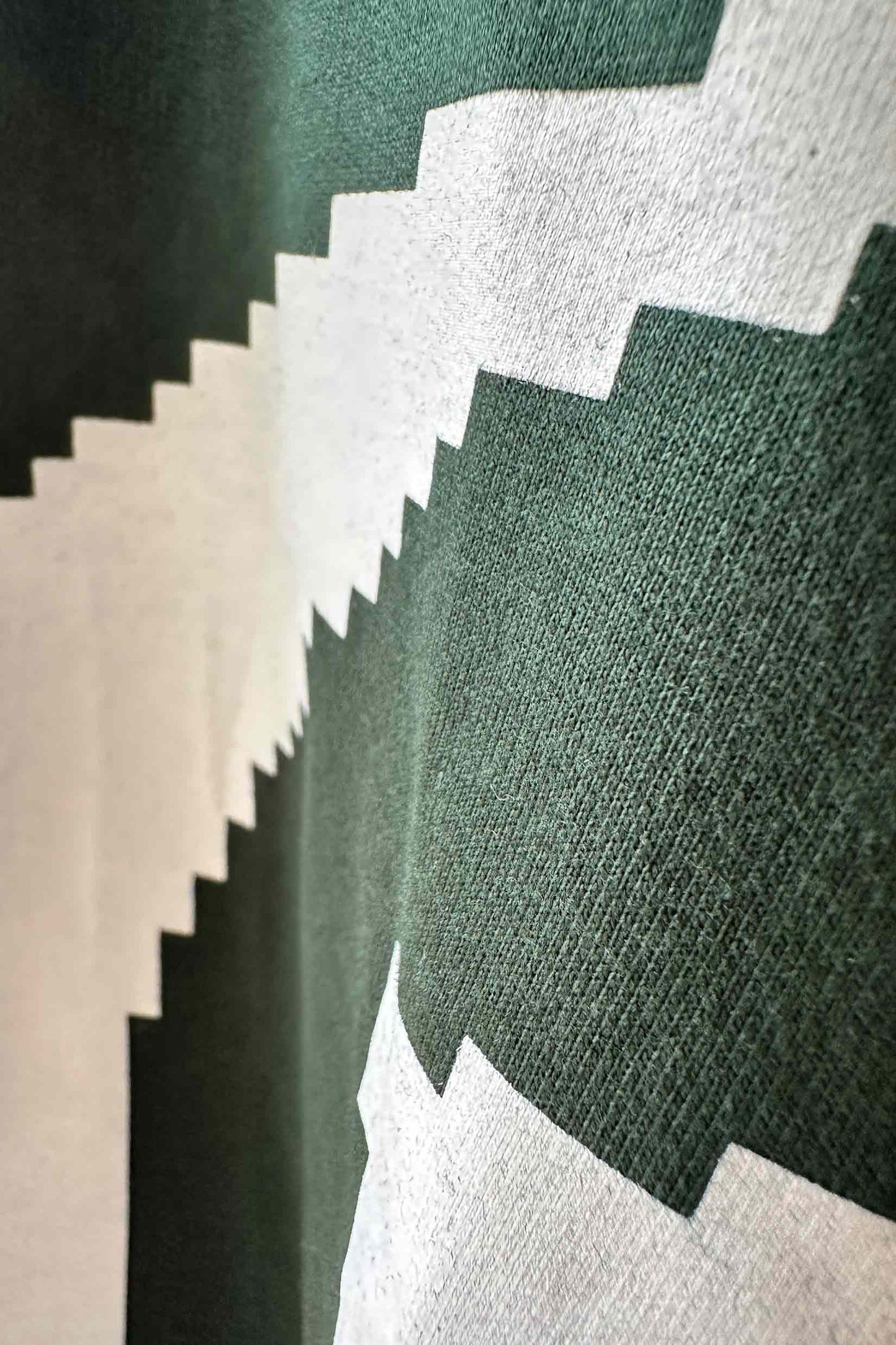 Stylera short sleeve streetwear tee close up of green cotton fabric with white pixelated zigzag graphic print