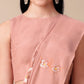 Model wearing a soft cotton saree with floral design in pastel pink, paired with elegant earrings