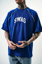 Person wearing a blue t-shirt with 'SWAG' printed on it against a white background