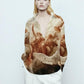 Stylera printed silk blouse with angelic Renaissance print worn by model with white trousers statement fashion tops for women