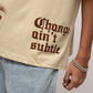 Stylera beige stencil art t-shirt with brown gothic Change aint subtle print distressed hem and model wearing jeans