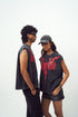 Stylera red graphic sleeveless t-shirt worn by male and female models styled with cap and denim shorts