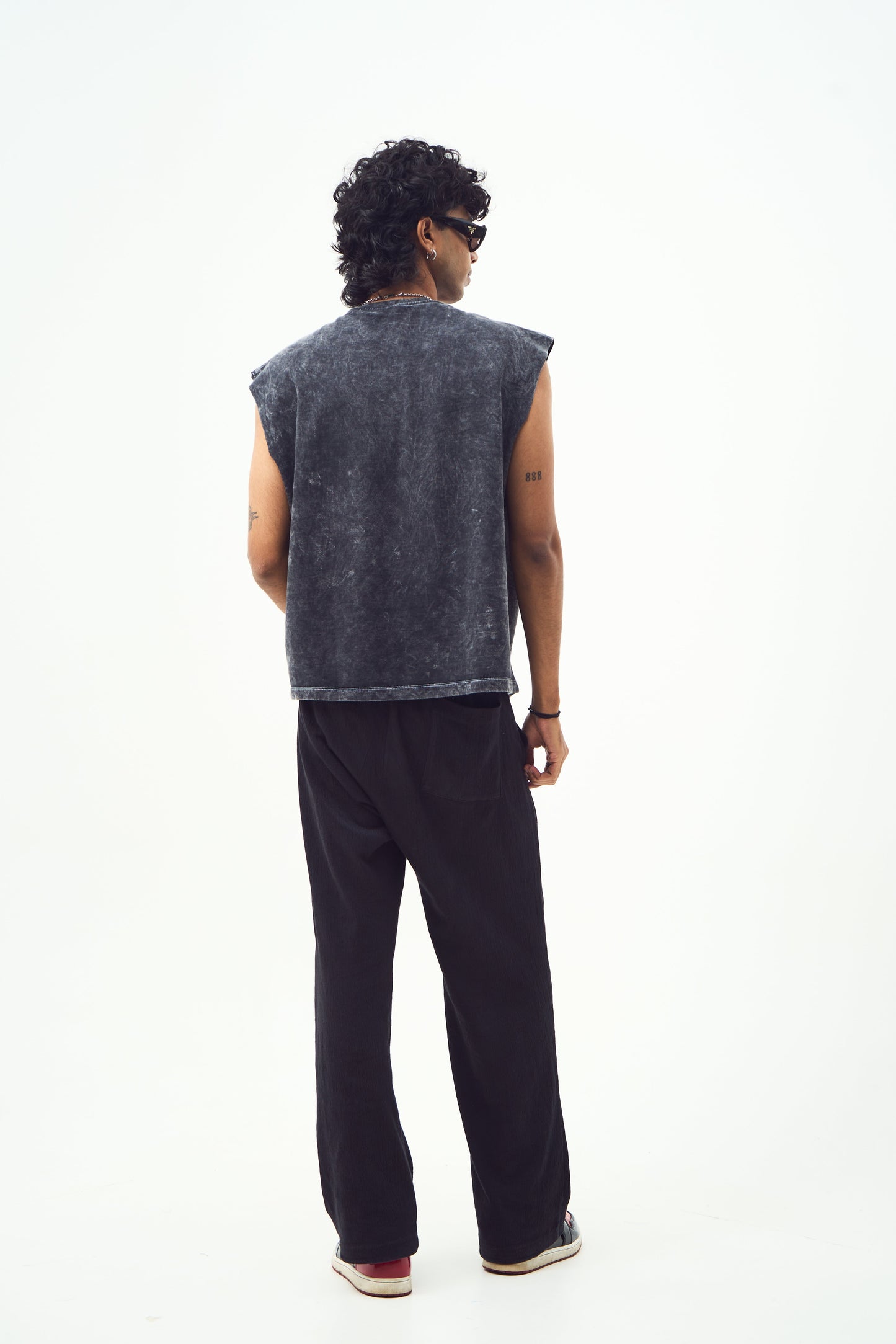 Male model back view wearing Stylera red graphic sleeveless t-shirt shown here in washed black with black pants