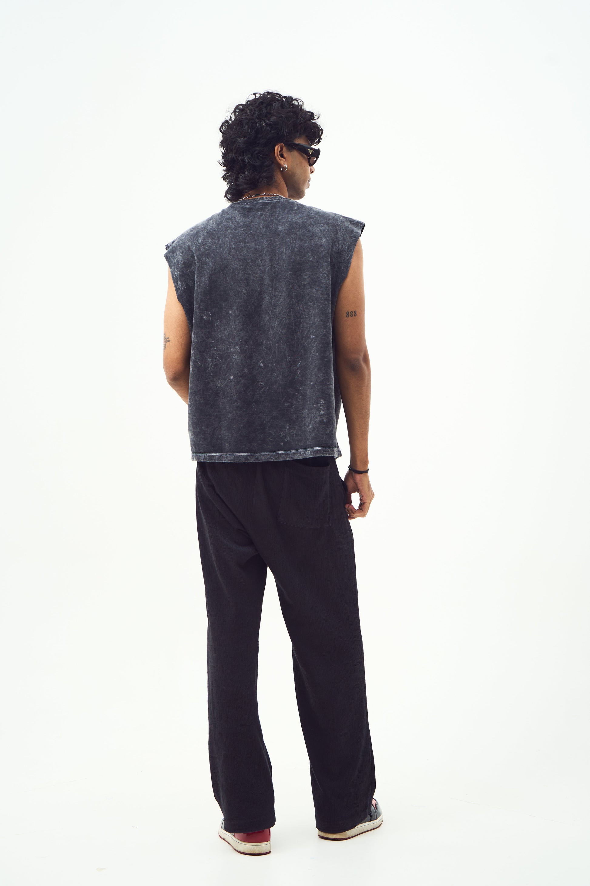 Male model back view wearing Stylera red graphic sleeveless t-shirt shown here in washed black with black pants