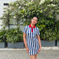 Woman posing outdoors in navy and white vertical striped mini dress for women with red polo collar