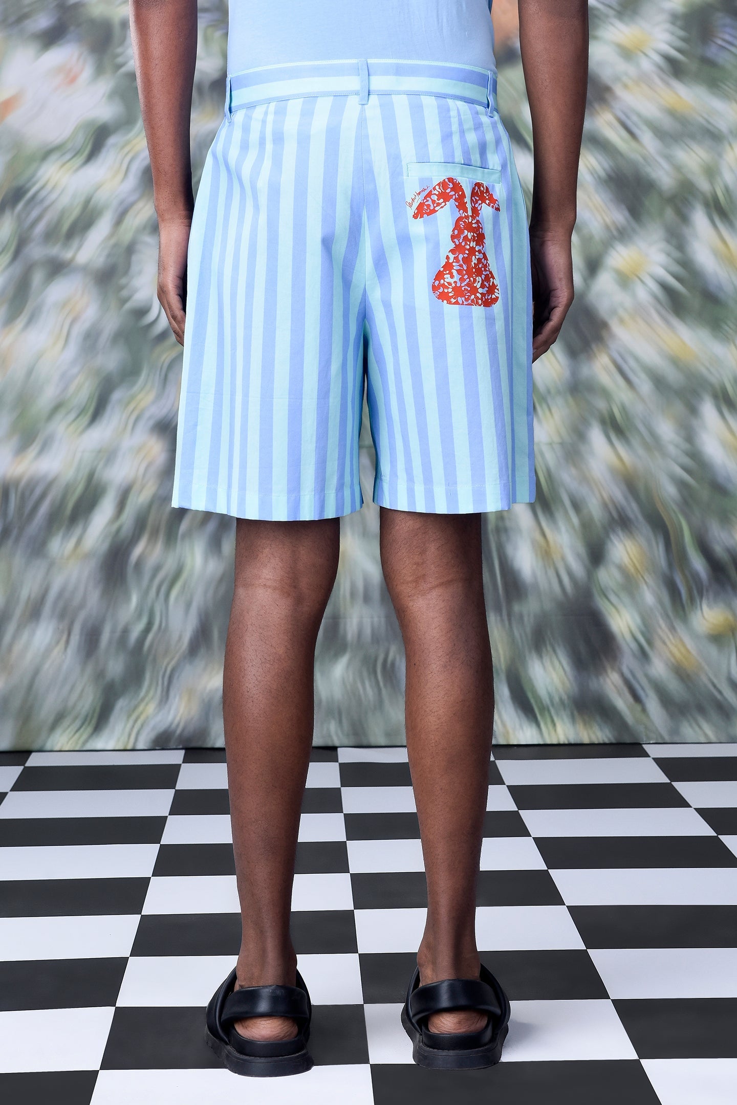 Back view of Stylera striped regular fit shorts light blue white stripes with red rabbit patch