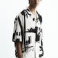 Stylera model wearing a black and white statement shirt short sleeve button down with abstract print