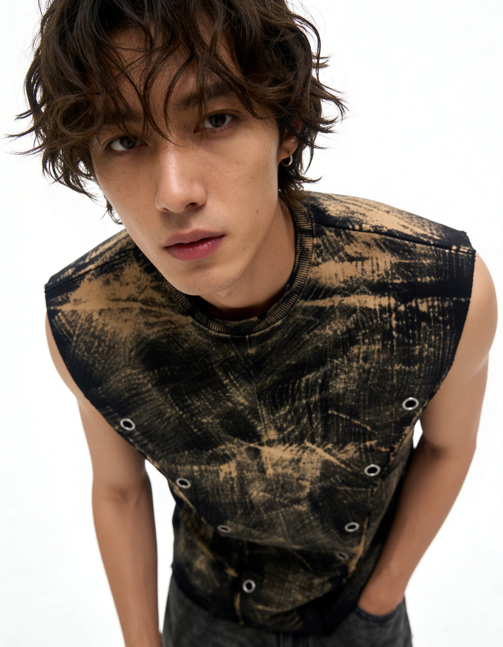 Person wearing a sleeveless, distressed black and gold top on a white background