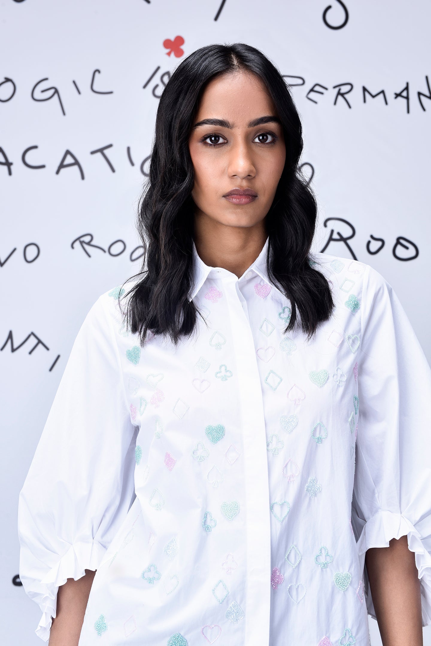 Model wearing Stylera white collared shirt with pastel motifs and ruffled sleeves stylish casual embroidered top