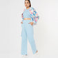 Trendy model wearing stylish co ord sets for women, featuring a floral bomber jacket and light blue pants