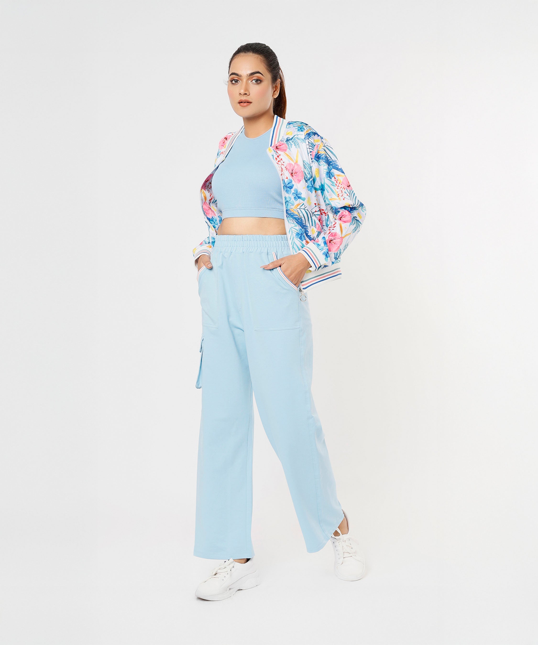Trendy model wearing stylish co ord sets for women, featuring a floral bomber jacket and light blue pants