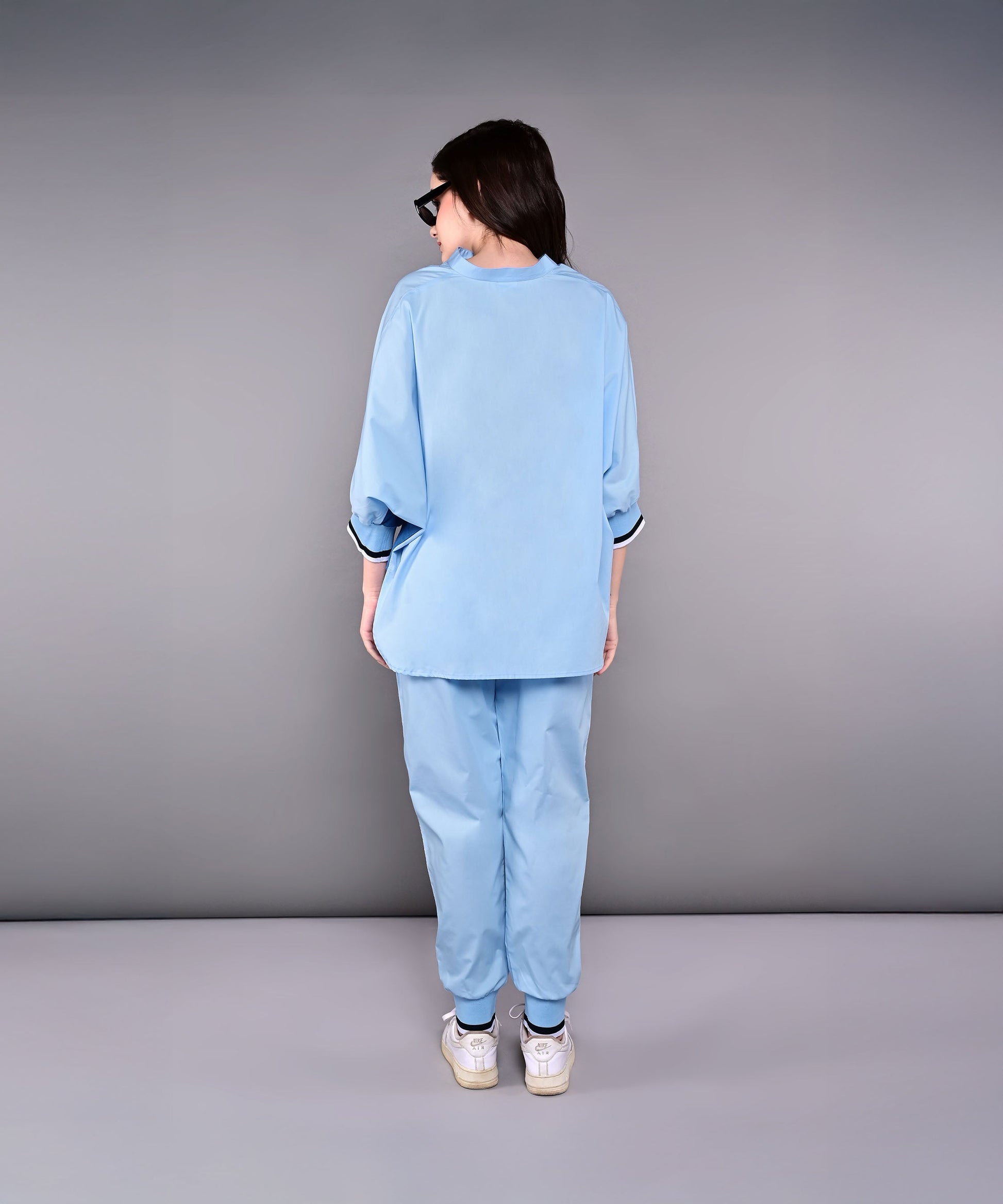 Back view of a stylish denim track suit in light blue by Stylera, featuring relaxed fit and comfortable fabric
