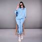 Woman wearing a stylish denim track suit in blue, paired with sunglasses and sneakers for a chic look