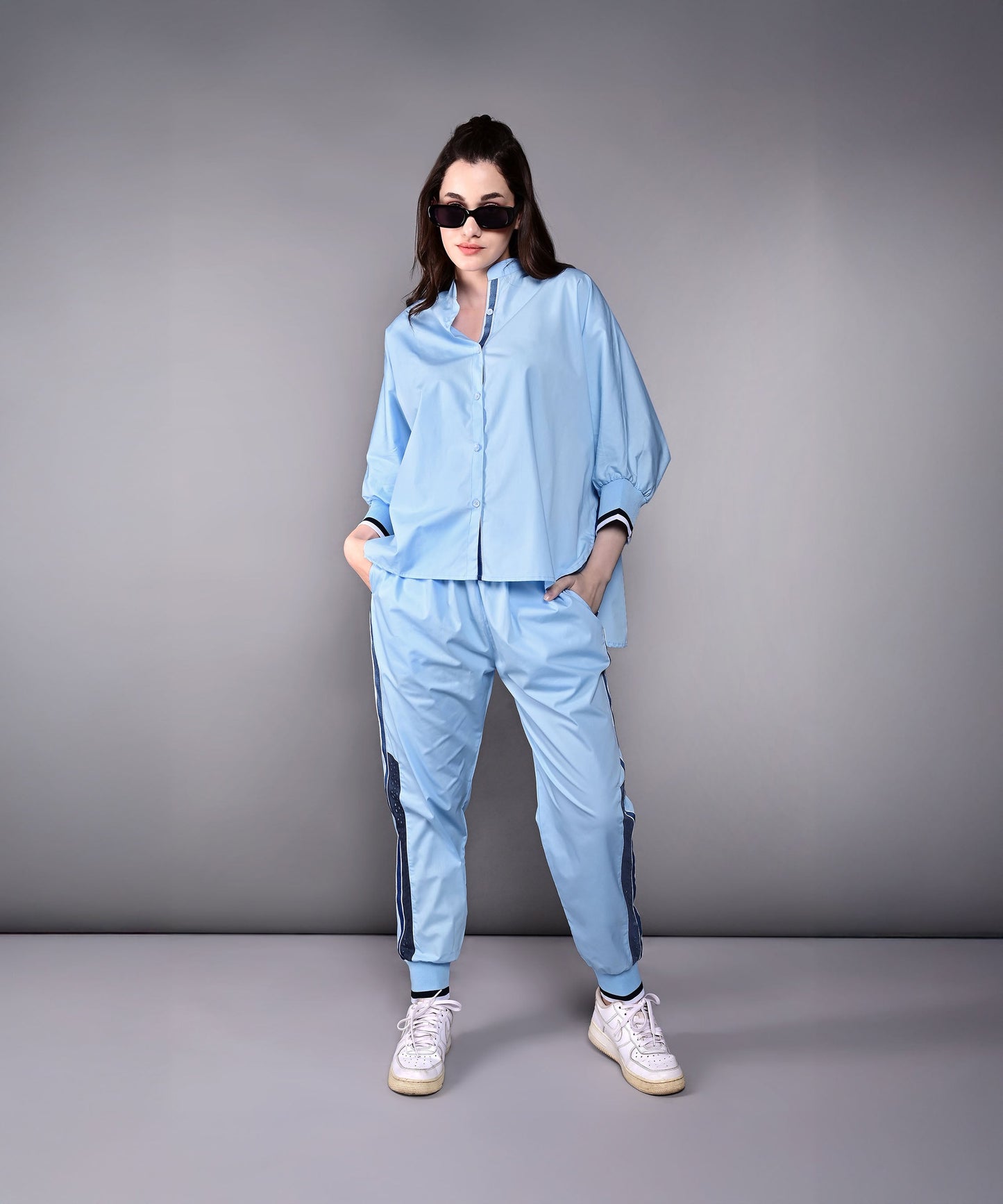 Model wearing a stylish denim track suit in light blue with sporty details and a relaxed fit
