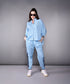 Model wearing a stylish denim track suit in light blue with sporty details and a relaxed fit