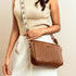 Stylish everyday sling bag in brown with a decorative strap, perfect for casual outings.