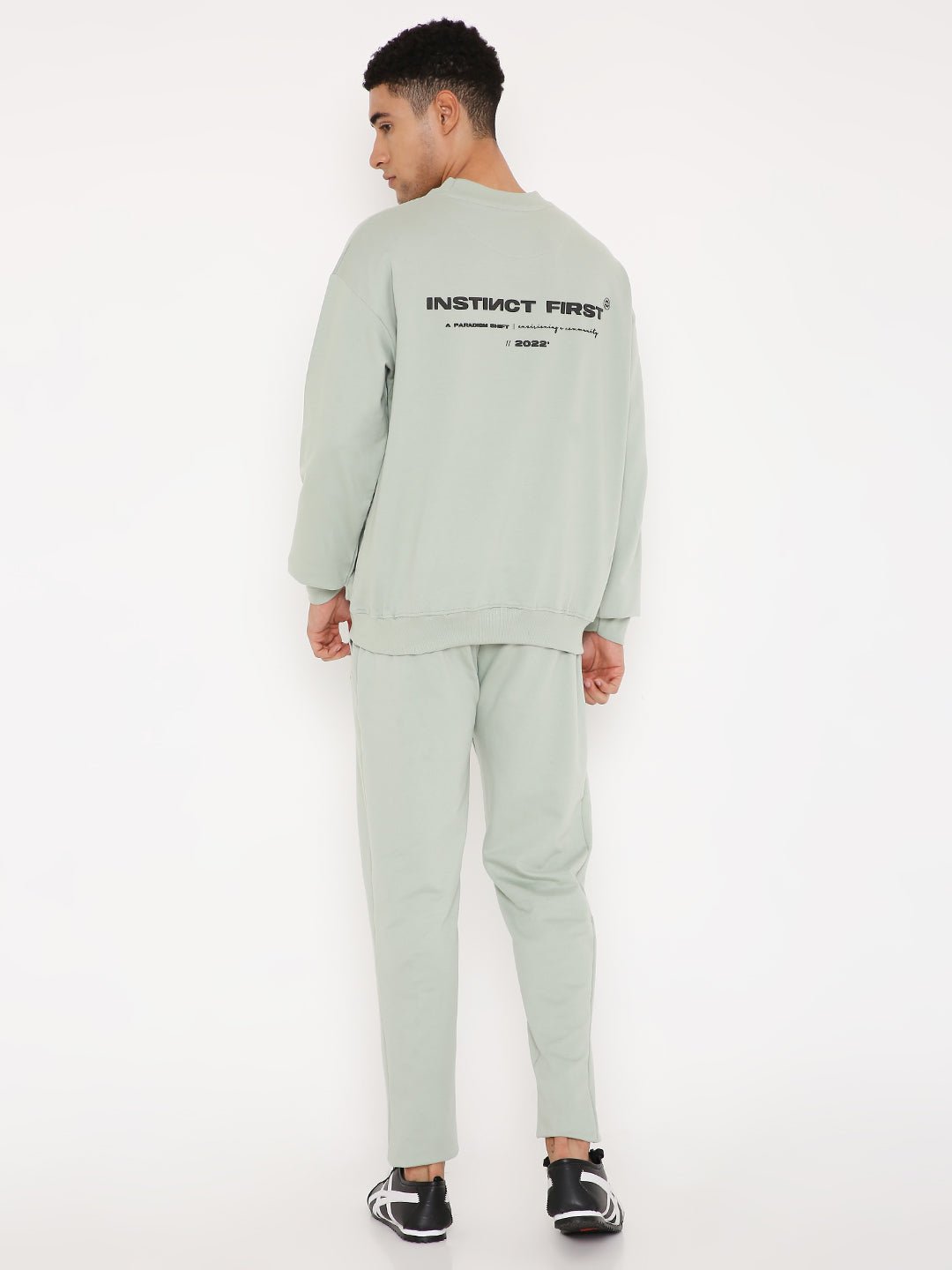 Stylera sage green sweatshirt back view on model with logo and matching pants stylish graphic sweatshirts for camping