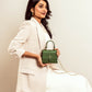 Stylish green purse with gold chain held by a woman in a white blazer for a chic look