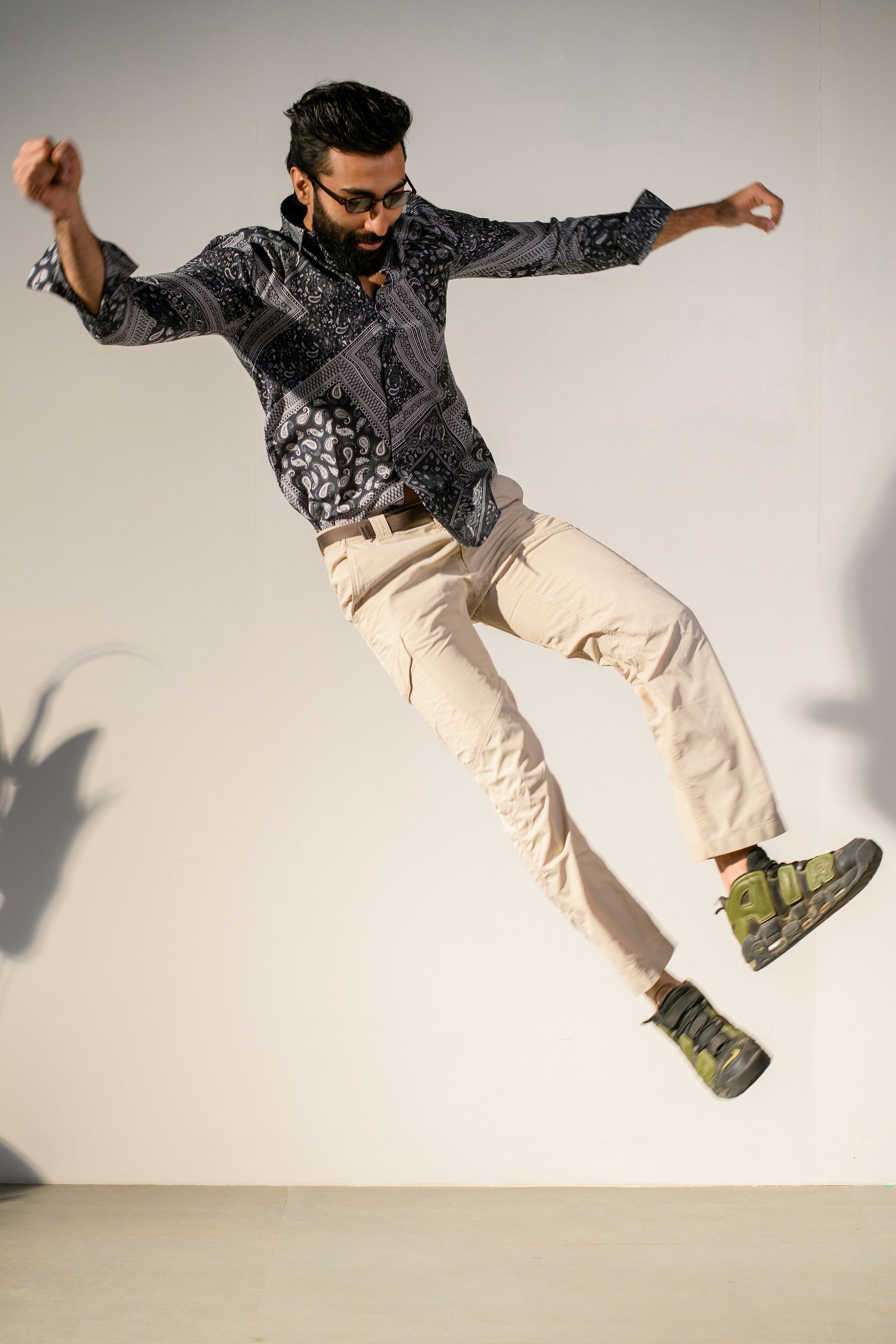 Man jumping in stylish paisley print shirt for men paired with casual pants and shoes