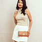 Stylish tan evening bag styled with a beige top and white skirt for a chic look