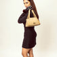 Stylish taupe shoulder bag showcased by a model wearing a chic black dress and gloves