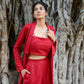 Model wearing a red stylish three piece set for parties with a matching top, pants, and jacket