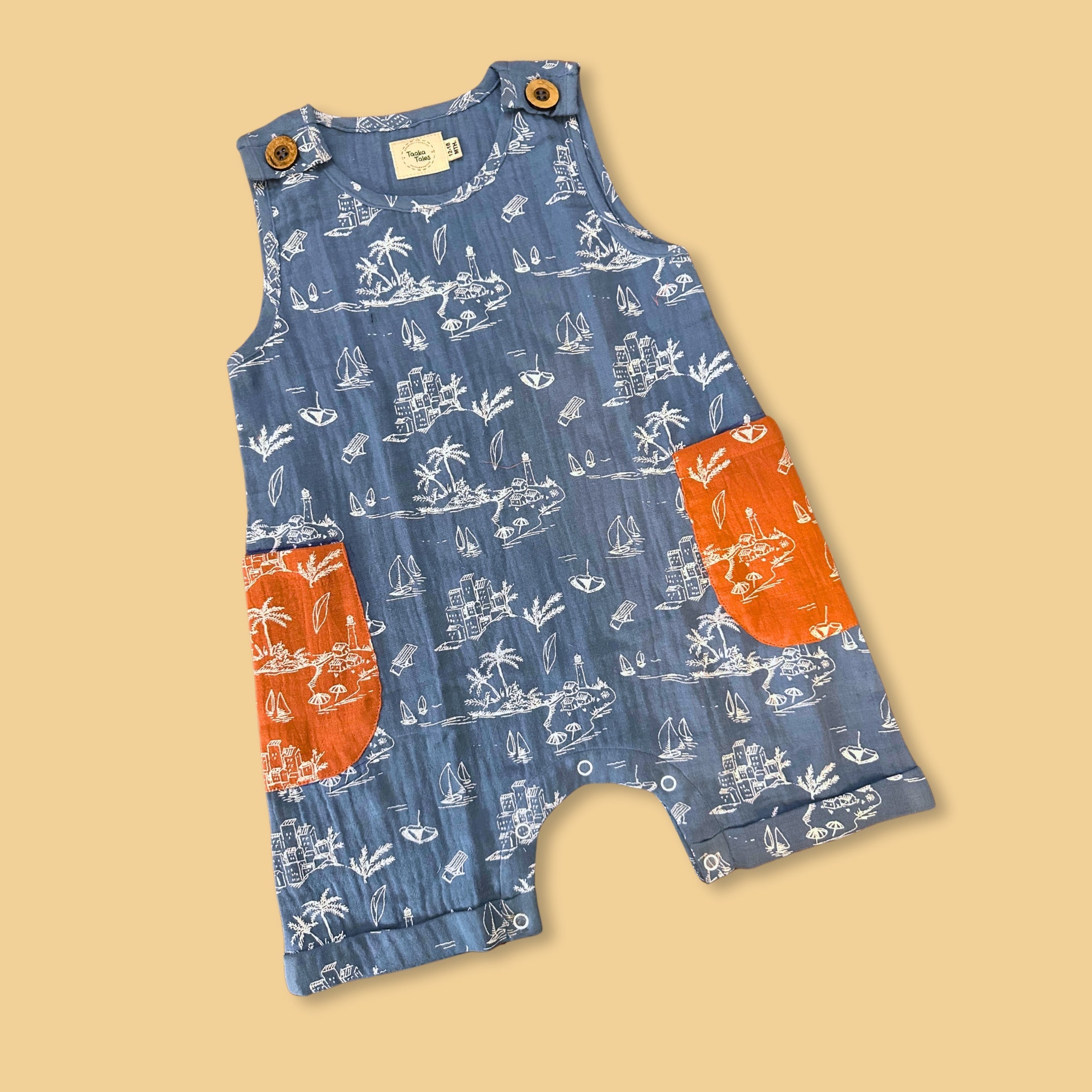 Stylera summer jumpsuit for kids with blue printed design and bright orange pockets