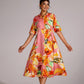 Model wearing a vibrant summer pink cotton dress with floral patterns and a flared silhouette