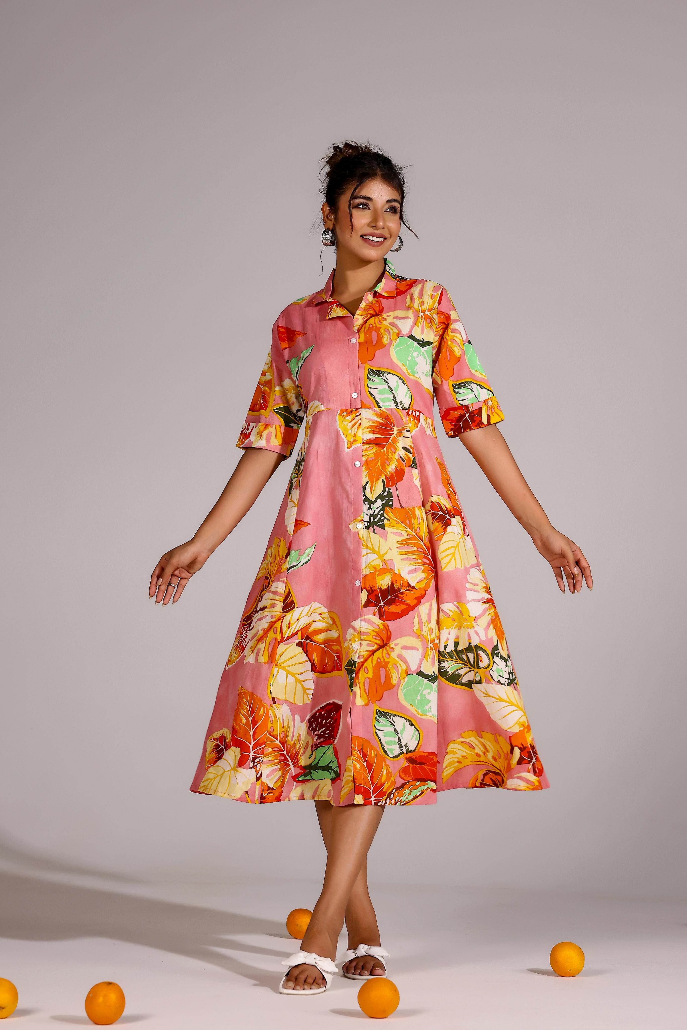 Model wearing a vibrant summer pink cotton dress with floral patterns and a flared silhouette
