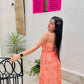 Stylera Muse casual backless maxi dress in orange paisley print worn by model outdoors showing strappy back and flowy hem