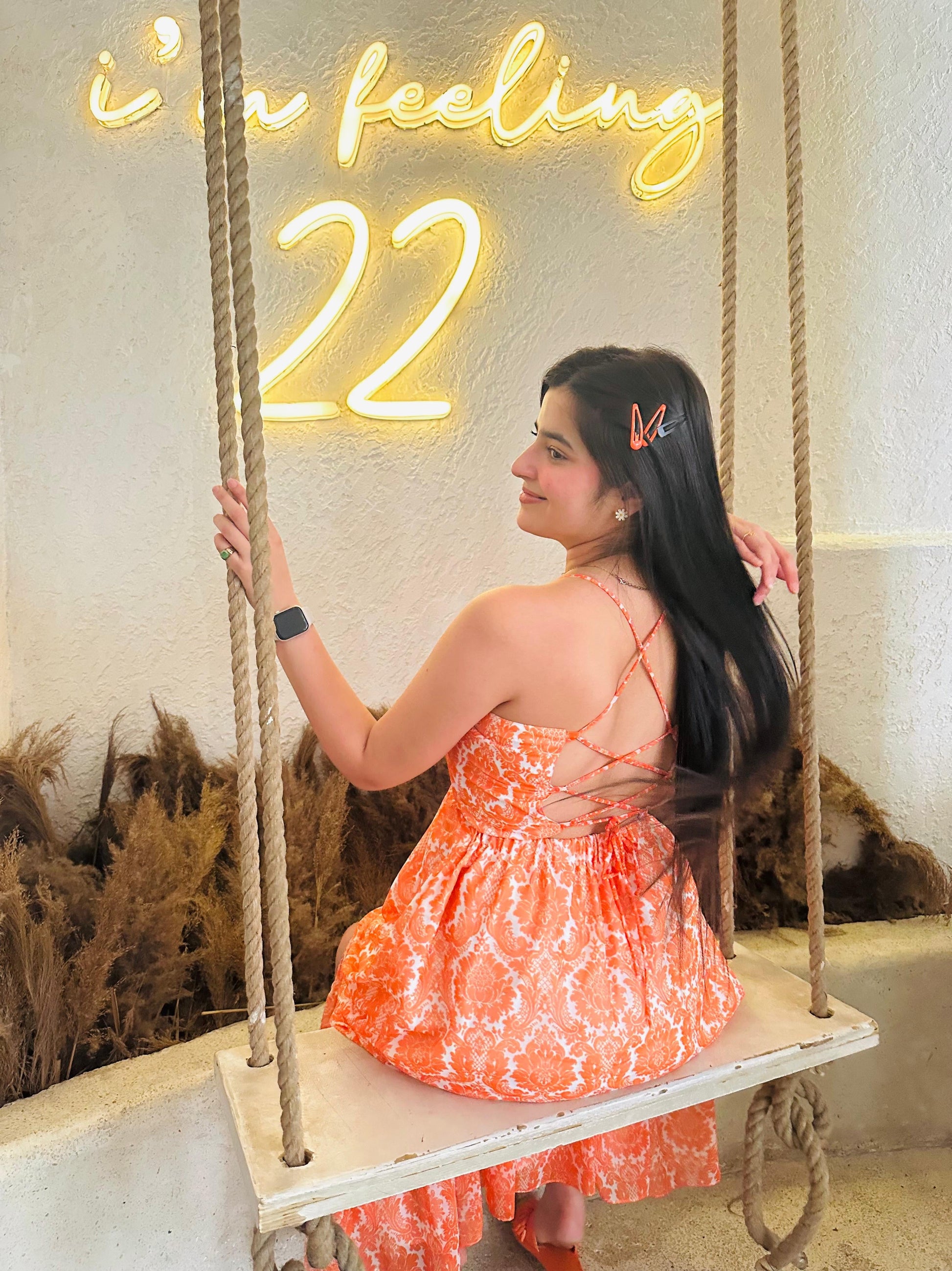 Stylera Muse casual backless maxi dress orange paisley woman on swing with criss cross back straps