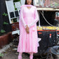 Model wearing a taffy pink anarkali suit set with a matching dupatta and leggings