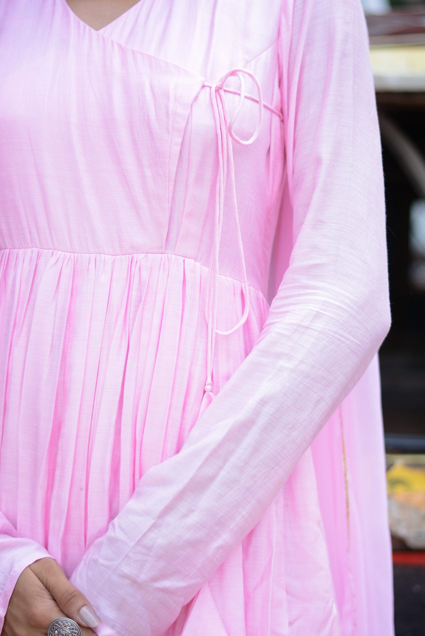 Close-up of a taffy pink anarkali suit set showcasing pleated design and elegant detailing